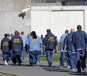 In this Feb. 26, 2013, file photo, inmates walk through the exercise yard at California State Prison Sacramento, near Folsom, Calif.