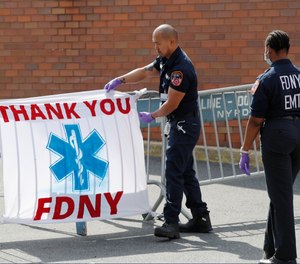 This photo from April 7, 2020, shows FDNY EMTs viewing a sign reading