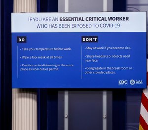 A chart outlining new guidelines by the CDC for essential workers is displayed during a briefing about COVID-19 in the James Brady Press Briefing Room of the White House, Wednesday, April 8, 2020, in Washington.