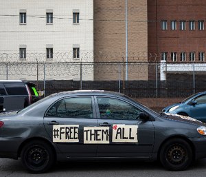 Dozens of protesters drive around Cook County Jail and the Leighton Criminal Courthouse in Chicago, honking their horns and chanting to demand the 