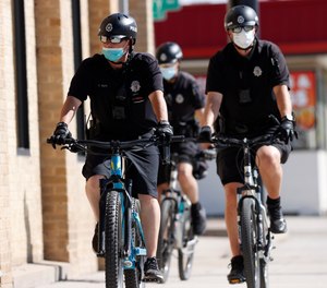 Denver Police Department officers wear face masks as they patrol on their bicycles in Denver on April 22, 2020.