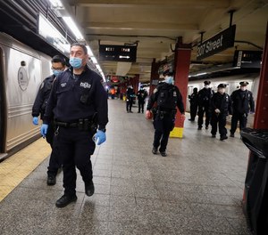 NYPD and MTA officers search cars for sleeping passengers and direct them to the exits at the 207th Street A-train station, Thursday, April 30, 2020, in the Manhattan.