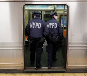 NYPD officers board a subway train in Manhattan on Thursday, April 30, 2020.