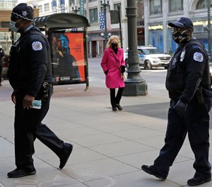 Chicago police officers wear masks as they walk on the street in downtown Chicago, Thursday, May 7, 2020.