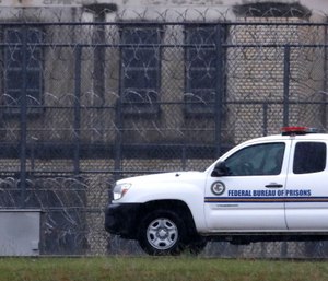 A Federal Bureau of Federal Prisons truck drives past barbed wire fences at the Federal Medical Center prison in Fort Worth, Texas. (AP Photo/LM Otero)