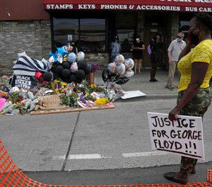 Protesters gather at a makeshift memorial in Minneapolis near the site where George Floyd was taken into police custody before he died.