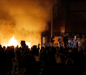 Crowds gather in front of the burning Minneapolis police 3rd Precinct building Thursday, May 28, 2020, in Minneapolis.