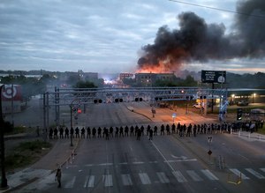Law enforcement officers amassed along Lake Street near Hiawatha Ave. as fires burned after a night of unrest and protests in the death of George Floyd early Friday, May 29, 2020 in Minneapolis. Floyd died after being restrained by Minneapolis police officers on Memorial Day. Image: David Joles/Star Tribune via AP
