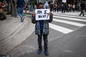 A boy holds a sign during a protest in downtown Los Angeles, Friday, May 29, 2020, over the death of George Floyd, who died in police custody on Memorial Day in Minneapolis. Image: AP Photo/Christian Monterrosa