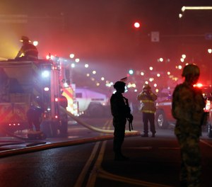 The National Guard standby as firefighters extinguish a blaze at a gas station Friday, May 29, 2020, in Minneapolis.