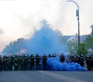 Minnesota State Police officers approach a crowd of protesters, Saturday, May 30, 2020, in Minneapolis following the death of George Floyd.