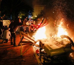 Demonstrators start a fire during a protest over the killing of George Floyd, Sunday, May 31, 2020, near the White House in Washington.