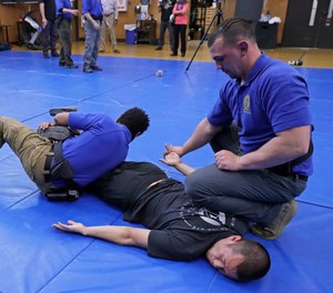 Washington State Criminal Justice Training Commission instructors conduct a demonstration of takedown and restraint techniques, which are part of the more than 700 hours of training police and other officers are required to go through in the state. 