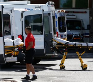 In this June 16, 2020, photo, medical transports and ambulances are parked outside the emergency-room entrance at Banner Desert Medical Center, in Mesa, Ariz. The American Ambulance Association is requesting an additional $2.62 billion in federal COVID-19 relief funds for ambulance services from the Department of Health and Human Services.