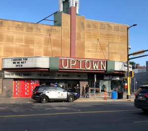 A police officer, far right, investigates the scene of a shooting as a person stands nearby Sunday, June 21, 2020, in Minneapolis' Uptown neighborhood.