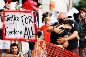 In this June 3, 2020, photo, people gather at the site where George Floyd died in Minneapolis. Americans overwhelmingly want clear standards for police on when officers may use force and consequences imposed on cops who do so excessively. Image: AP Photo/Julio Cortez