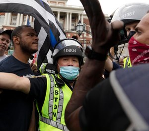 Police step between demonstrators at a pro-police rally, left, and counterprotesters outside the Statehouse, Saturday, June 27, 2020, in Boston.