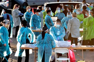 In this photo taken Saturday, June 27, 2020, medical personnel prepare to test hundreds of people lined up in vehicles in Phoenix's western neighborhood of Maryvale in Phoenix for free COVID-19 tests organized by Equality Health Foundation, which focuses on care in underserved communities. Image: AP Photo/Matt York