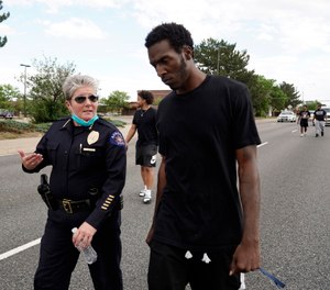 Interim Aurora Police Chief Vanessa Wilson and Jay B. confer as protesters march north on South Chambers Road during a peaceful protest against police brutality following the death of George Floyd in Aurora, Colo.