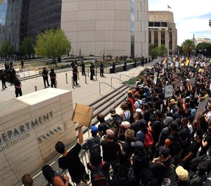 In this June 2, 2020, file photo, demonstrators kneel in front of LAPD headquarters during a protest in Los Angeles over the death of George Floyd.