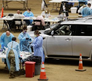 Workers administer COVID-19 tests at a drive-through facility set up in the Williamson County Agricultural Center, Thursday, July 2, 2020, in Franklin, Tenn. Confirmed COVID-19 cases have risen in 40 of 50 states over the past few weeks.