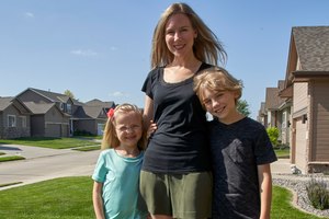 Tara Carlson poses for a photo with her children Kyler, 9, and Alayna, 6, outside their home in Omaha, Neb., Tuesday, July 7, 2020. Carlson pulled her kids out of summer camp at the last minute, losing $300 in deposits. Image: AP Photo/Nati Harnik