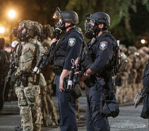 Agents from different components of the Department of Homeland Security are deployed to protect a federal courthouse in Portland, Ore., on Sunday, July 5, 2020. (Doug Brown via AP)