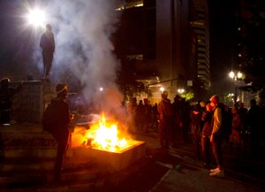 In this July 4, 2020, photo, protesters gather near a fire in downtown Portland, Ore. Oregon's largest city is in crisis as violent protests have wracked downtown for weeks. Image: Beth Nakamura/The Oregonian via AP