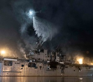 A helicopter from Helicopter Sea Combat Squadron (HSC) 3 combats a fire aboard the amphibious assault ship USS Bonhomme Richard (LHD 6) at Naval Base San Diego, Tuesday, July 14, 2020. A Navy statement says there's been significant progress and much less smoke is being emitted from the USS Bonhomme Richard on Tuesday.