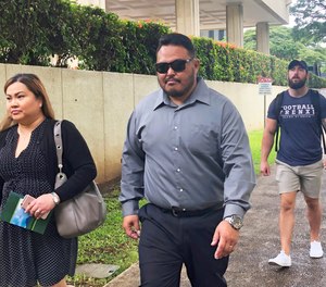 In this Sept. 25, 2019 file photo, former Honolulu police officer Reginald Ramones, center, walks down a street in Honolulu.