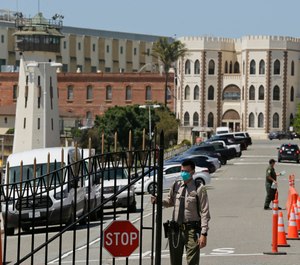 In this July 9, 2020, file photo, a correctional officer closes the main gate at San Quentin State Prison in San Quentin, Calif. (AP Photo/Eric Risberg, File)