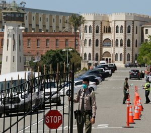A correctional officer closes the main gate at San Quentin State Prison in San Quentin, Calif.