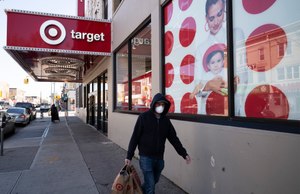 In this April 6, 2020 photo, a customer wearing a mask carries his purchases as he leaves a Target store during the coronavirus pandemic in the Brooklyn borough of New York. Target has joined a growing list of major retailers that will require customers at all their stores to wear face coverings. Image: AP Photo/Mark Lennihan