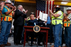 In this April 10, 2019, photo, President Donald Trump holds up an executive order on energy and infrastructure after signing it at the International Union of Operating Engineers International Training and Education Center in Crosby, Texas. Image: AP Photo/Evan Vucci