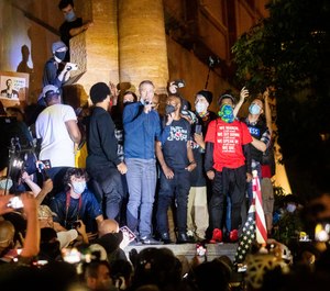 Portland Mayor Ted Wheeler speaks to Black Lives Matter protesters on Wednesday, July 22, 2020, in Portland, Ore. (AP Photo/Noah Berger)