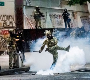 Federal officers use crowd control munitions to disperse protesters outside the Mark O. Hatfield United States Courthouse on Tuesday, July 21, 2020, in Portland, Ore. (AP Photo/Noah Berger)