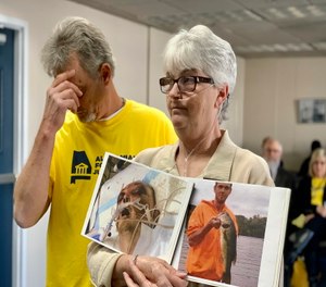 Sandy Ray, holds photos of her son, Steven Davis, during a news conference at the Alabama Statehouse in Montgomery.