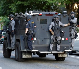 Seattle Police ride on a vehicle behind bicycle police during a Black Lives Matter protest march, Saturday, July 25, 2020, in Seattle.