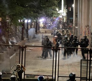 Federal officers walk out in formation to launch tear gas at demonstrators at the Mark O. Hatfield United States Courthouse Sunday, July 26, 2020, in Portland, Ore. (AP Photo/Marcio Jose Sanchez)