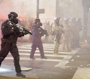 Federal officers deploy tear gas and crowd control munitions at demonstrators during a Black Lives Matter protest at the Mark O. Hatfield United States Courthouse Tuesday, July 28, 2020, in Portland, Ore.