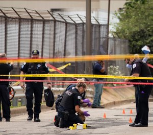 Chicago Police investigate at the 25th District station on the Northwest Side, after several officers were shot outside the station, Thursday, July 30, 2020. (Ashlee Rezin Garcia/Chicago Sun-Times via AP)