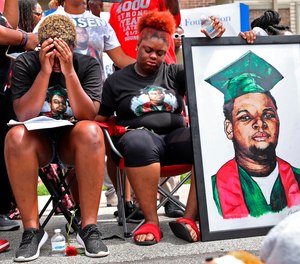 Trinetta Brown, left, 19, and Triniya Brown become emotional during a memorial service for their brother, Michael Brown, Thursday, Aug. 9, 2018, in Ferguson, Mo.