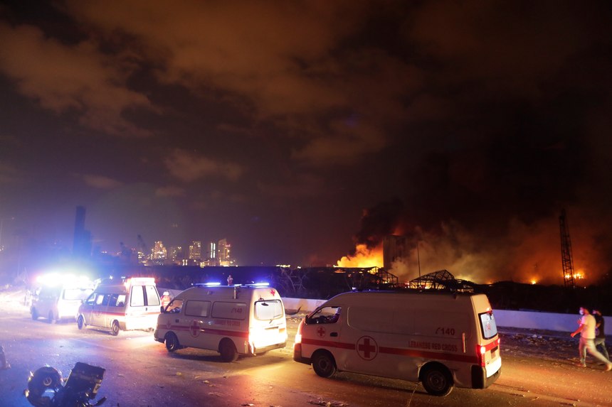 Ambulances drive past the site of a massive explosion in Beirut, Lebanon, Tuesday, Aug. 4, 2020. Massive explosions rocked downtown Beirut on Tuesday, flattening much of the port, damaging buildings and blowing out windows and doors as a giant mushroom cloud rose above the capital. Witnesses saw many people injured by flying glass and debris.