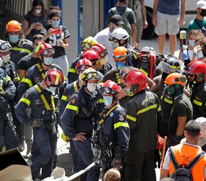 French and Lebanese firemen search in the rubble of a building after the Tuesday explosion at the seaport of Beirut, in Beirut, Lebanon, Thursday, Aug. 6, 2020.