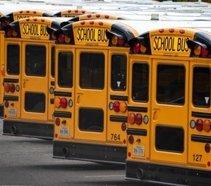 In this July 24, 2020 file photo, Fairfax County Public School buses are lined up at a maintenance facility in Lorton, Va.