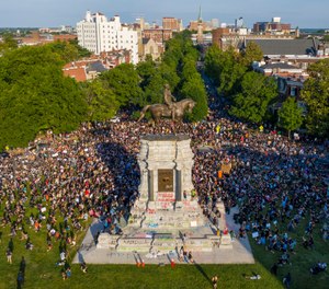 This Tuesday June 2, 2020 file photo shows a large group of protesters gather around the statue of Confederate General Robert E. Lee on Monument Avenue near downtown in Richmond, Va. (AP Photo/Steve Helber)
