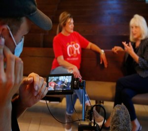 Teresa Stanfield, seated at center, the Oklahoma field director with Virginia-based Prison Fellowship, and Teresa Peden, right, pastor of recovery ministry at Crossing Community Church, are pictured in the camera display of videographer Drew Darby in Oklahoma City.