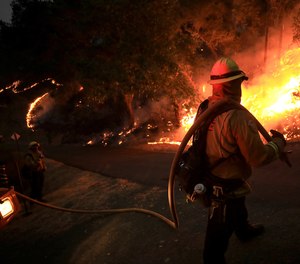 Chase Taber of CAL FIRE monitors a firing operation during the Hennessey Fire in Napa County, California.