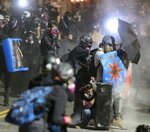 Protesters confront federal officers outside of the ICE building in Portland, Ore., Wednesday, Aug. 19, 2020. (Sean Meagher/The Oregonian via AP)