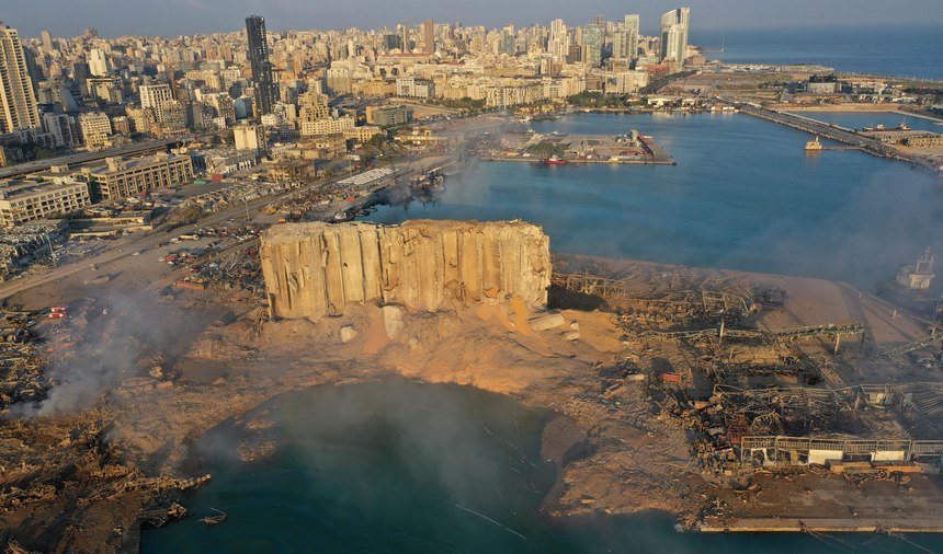 FILE - In this August 5, 2020 file photo, smoke rises from the scene of an explosion that hit the seaport of Beirut, Lebanon. It was 20 minutes before 6:08 p.m. when the Beirut fire brigade received the call from an employee at the nearby port reporting a big fire. Ten firefighters, including a female paramedic, piled into a fire engine and an ambulance and raced toward the scene, and their ultimate death.